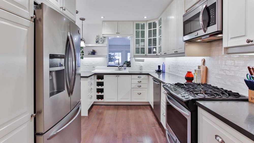 A white, modern kitchen with a Viking refrigerator